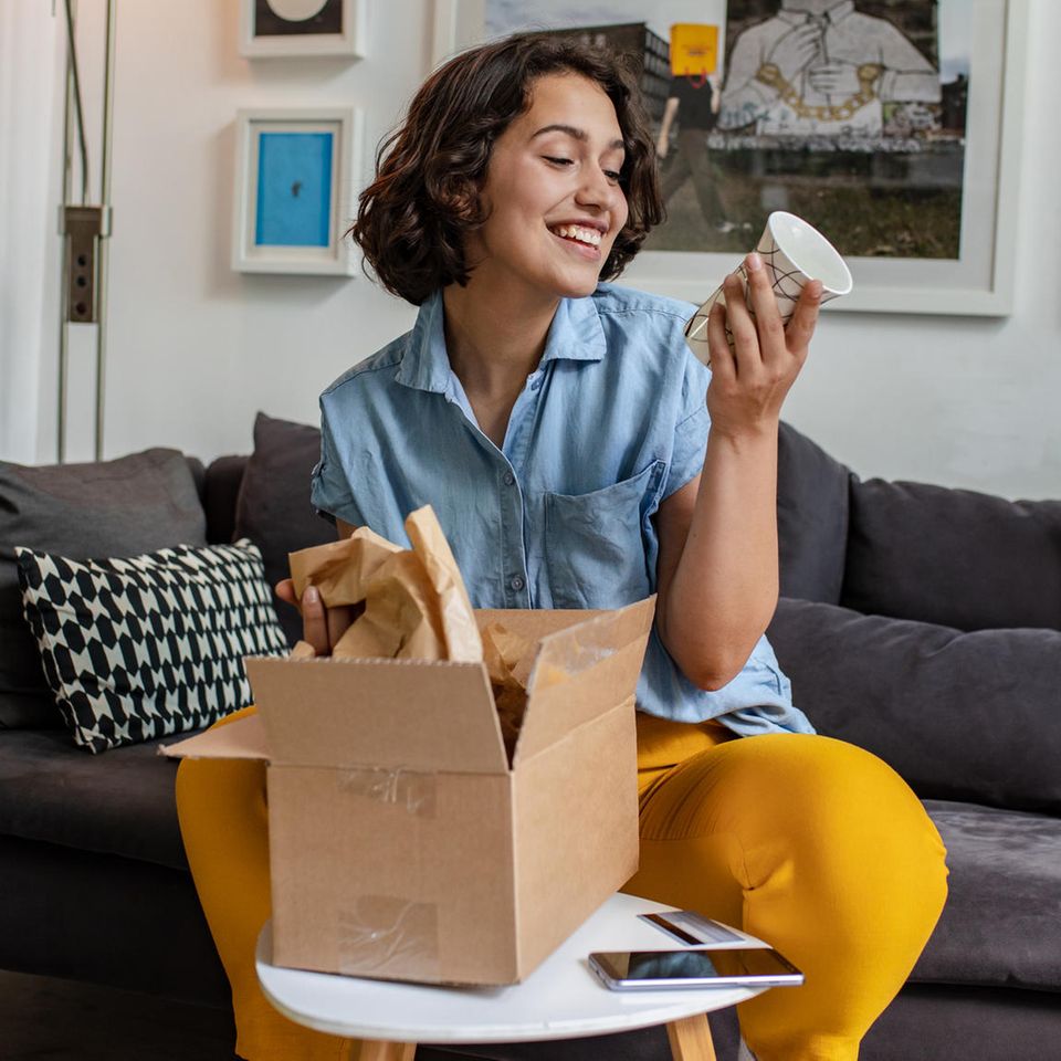 Online-Shopping: Frau packt ein Paket aus