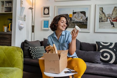 Online-Shopping: Frau packt ein Paket aus