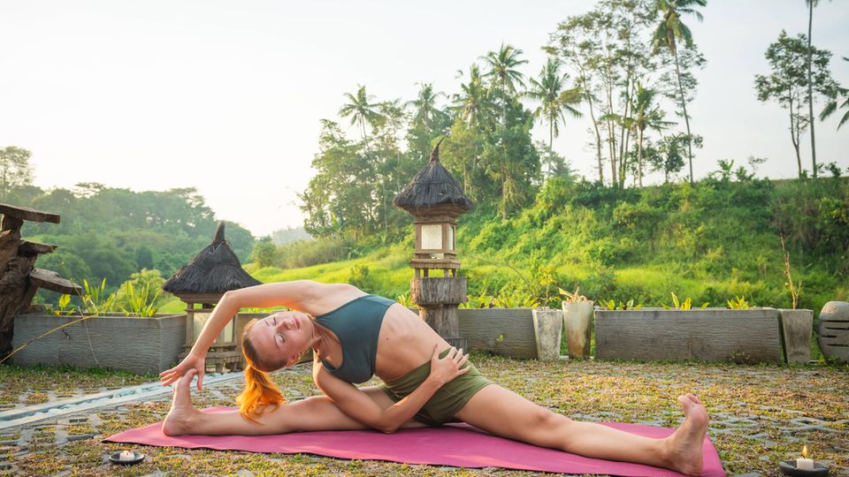 Frau übt Yoga in einem tropischen Land