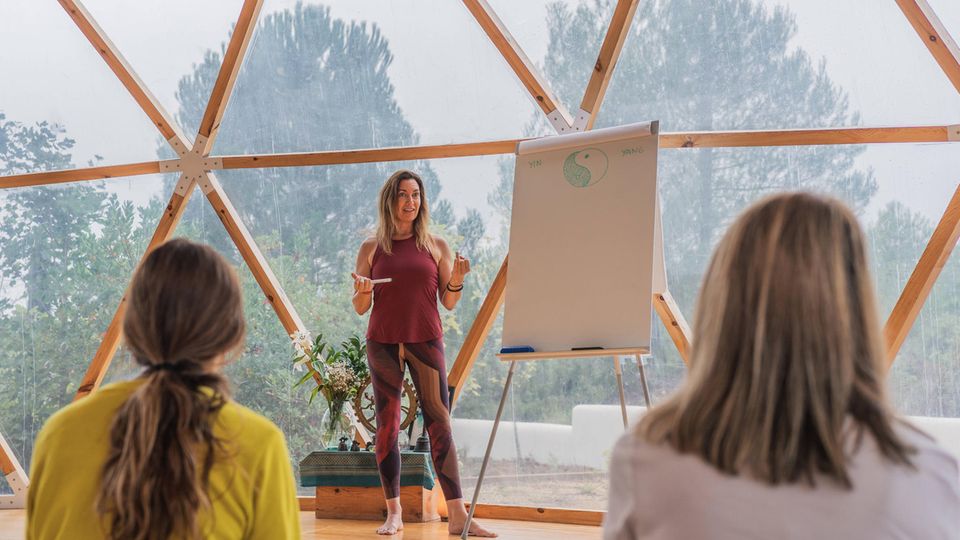 Frau vor einem Whiteboard bei einer Yogalehrerausbildung