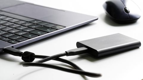 Deals und Angebote: Mobile SSD Festplatte liegt neben einem Laptop