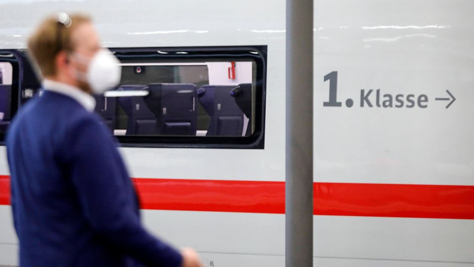 Ein Schaffner steht vor einem Wagen der 1. Klasse der deutschen Bahn