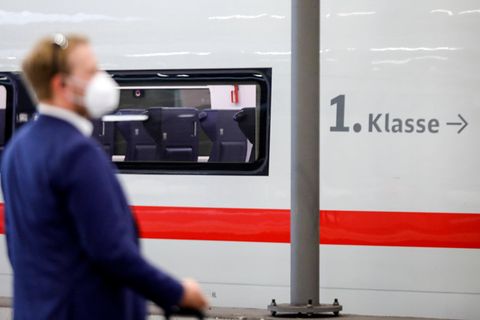 Ein Schaffner steht vor einem Wagen der 1. Klasse der deutschen Bahn