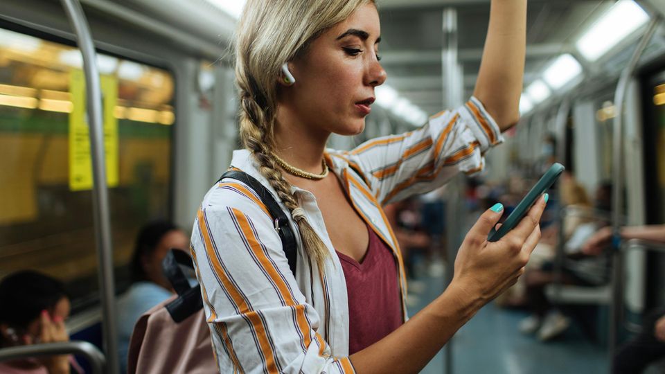 Frau nutzt Handy in der Bahn