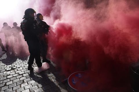 Am Tag X in Leipzig sind behelmte Polizisten in roten Rauch eingehüllt