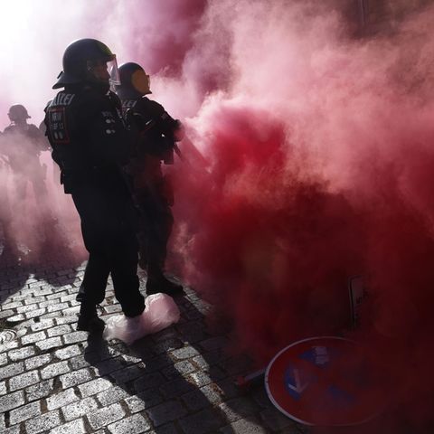 Am Tag X in Leipzig sind behelmte Polizisten in roten Rauch eingehüllt