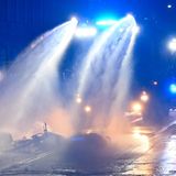 Ein Wasserwerfer der Polizei löscht eine brennende Barrikade im Stadtteil Connewitz. Unweit davon wurden nach Polizeiangaben eine Polizeiwache mit Steinen beworfen und weitere Barrikaden angezündet.