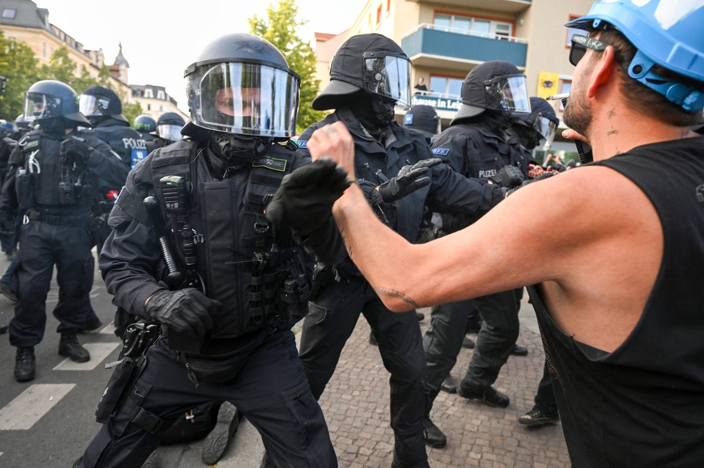Ein Polizist wehrt einen Demonstranten ab. Nach den Demonstrationen in Leipzig-Connewitz hat ein Haftrichter bis zum Samstagabend fünf Haftbefehle erlassen. Betroffen seien fünf Männer im Alter zwischen 20 und 32 Jahren, die bereits in der Nacht zum Samstag bei Ausschreitungen festgenommen worden seien.