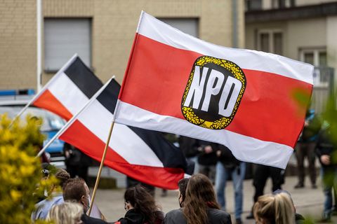Anhänger der NPD schwenken Fahnen