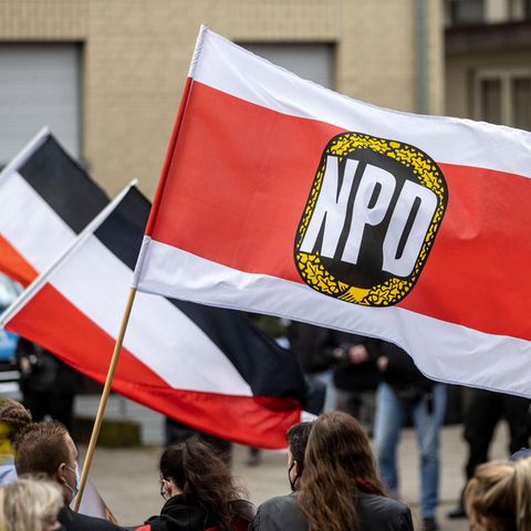 Anhänger der NPD schwenken Fahnen