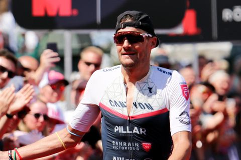 Triathlet Jan Frodeno klatscht im Ziel beim Ironman in Hamburg mit Zuschauern ab