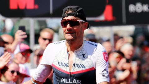 Triathlet Jan Frodeno klatscht im Ziel beim Ironman in Hamburg mit Zuschauern ab