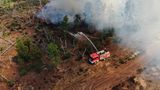 Einsatzkräfte der Feuerwehr bekämpfen in einem Waldstück nahe Jüterbog das Feuer
