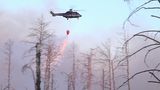 Ein Löschhubschrauber wirft Wasser ab über einem Waldbrand in einem munitionsbelasteten Gebiet bei Jüterbog