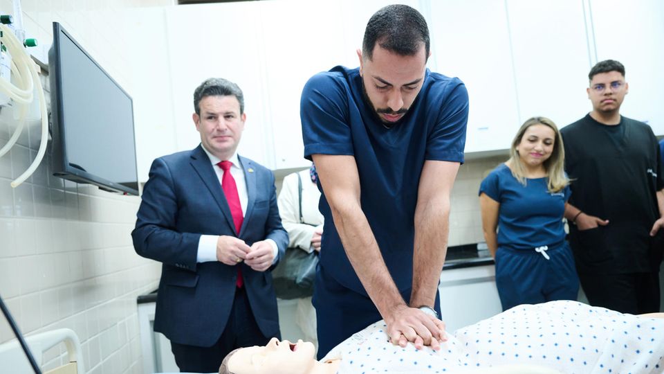 Ein Pfleger zeigt Hubertus Heil die Ausbildung an einer Simulationspuppe