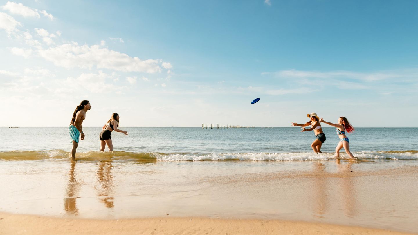 Menschen beschäftigen sich gemeinsam mit Strandspielzeug.