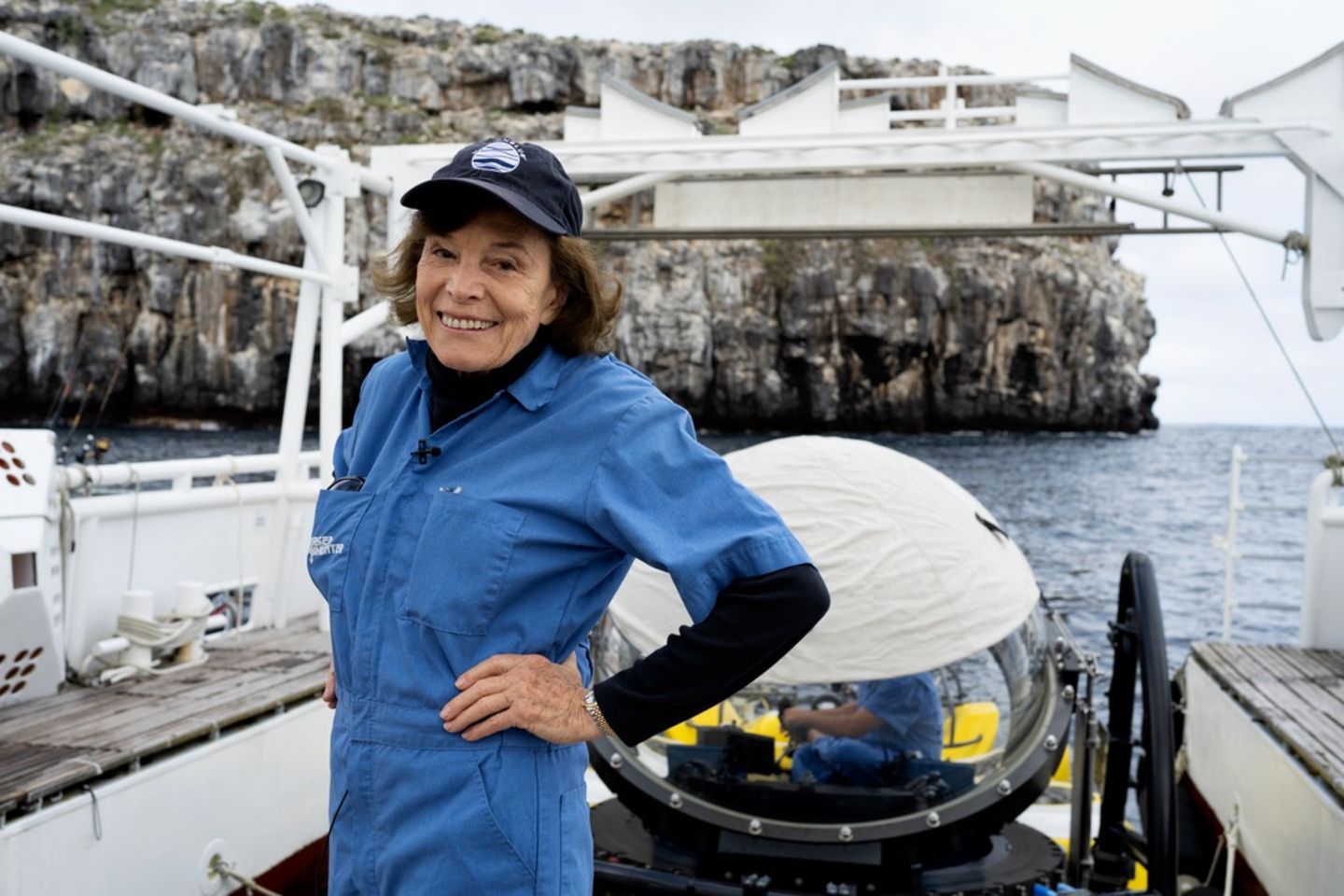 Die 87-jährige Meeresbiologin Sylvia Earle steht mit einem blauen Overall auf einem Boot