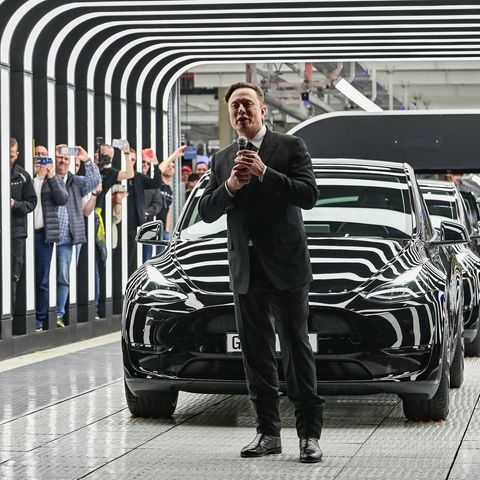 Dietmar Woidke, Olaf Scholz und Elon Musk stehen vor einem Auto in der Tesla-Fabrik in Brandenburg