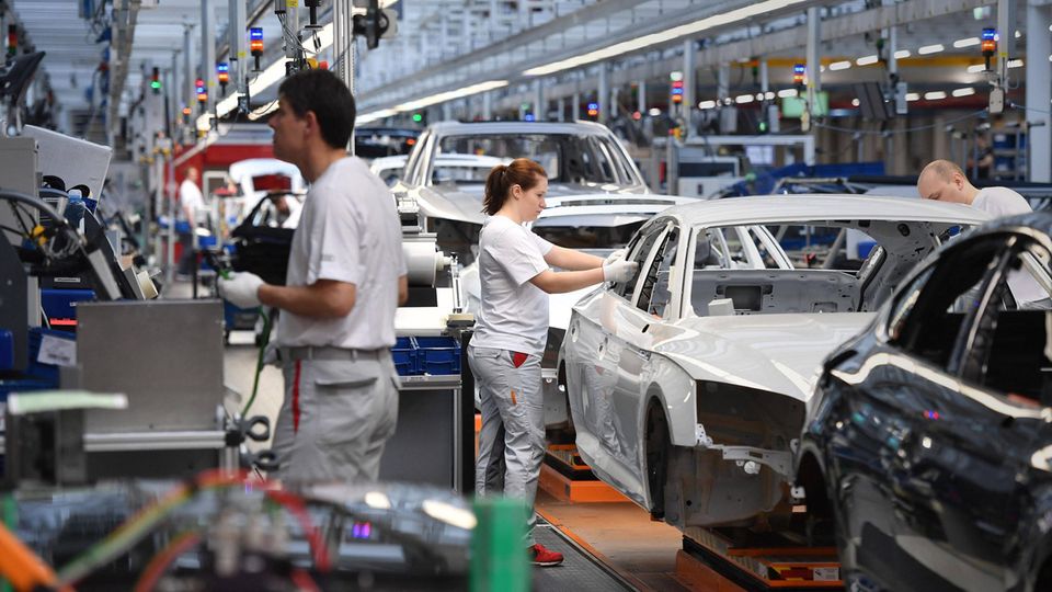 Beschäftigte arbeiten an einem Produktionsband in einem Auto-Werk