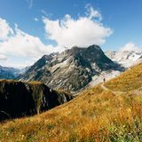 Ein schmaler Pfad führt auf den Mont Blanc, dessen Gipfel schroff in der Sonne liegt