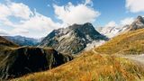 Ein schmaler Pfad führt auf den Mont Blanc, dessen Gipfel schroff in der Sonne liegt