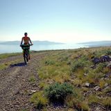 Eine Frau auf einem Mountainbike fährt in Kroatien an der Adria entlang