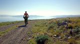 Eine Frau auf einem Mountainbike fährt in Kroatien an der Adria entlang