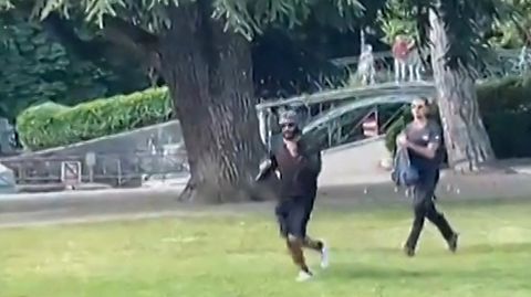 Ein Mann flieht mit einem Messer bewaffnet über den Rasen an einem Spielplatz in Annecy, Frankreich