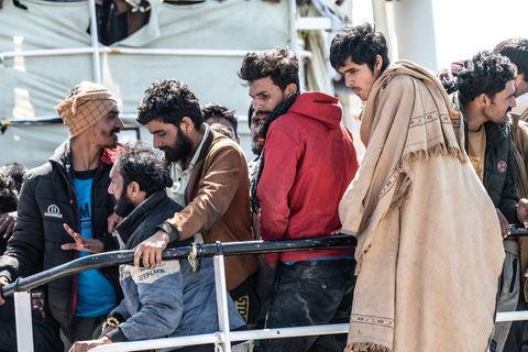 Geflüchtete gehen in Italien von Bord eines Schiffes um Asyl zu beantragen