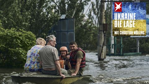 Rettungskräfte evakuieren Bewohner in einem Boot aus einem überfluteten Stadtteil in Cherson