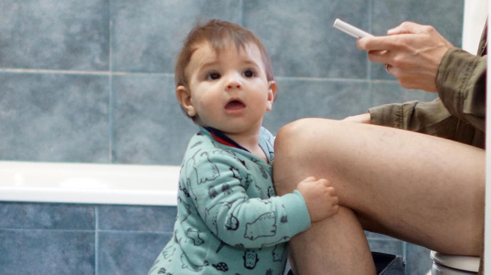 Mutter auf Toilette mit Kindern im Badezimmer