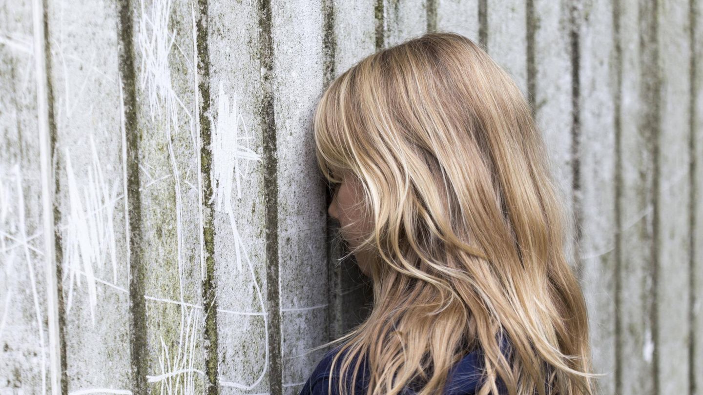Kinder-Psyche Ein Kind lehnt traurig den Kopf gegen eine Wand