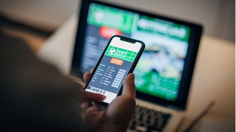 Sportwetten: Ein Mann wettet am Handy