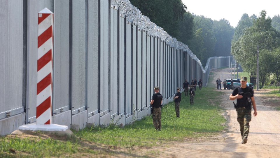 Polnische Grenzschützer patrouillieren an einem neu errichteten Grenzzaun zwischen Polen und Belarus