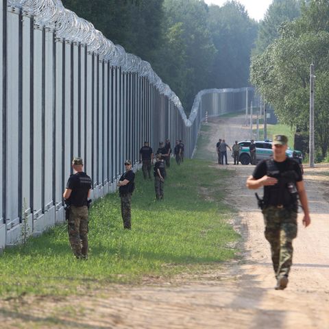 Polnische Grenzschützer patrouillieren an einem neu errichteten Grenzzaun zwischen Polen und Belarus