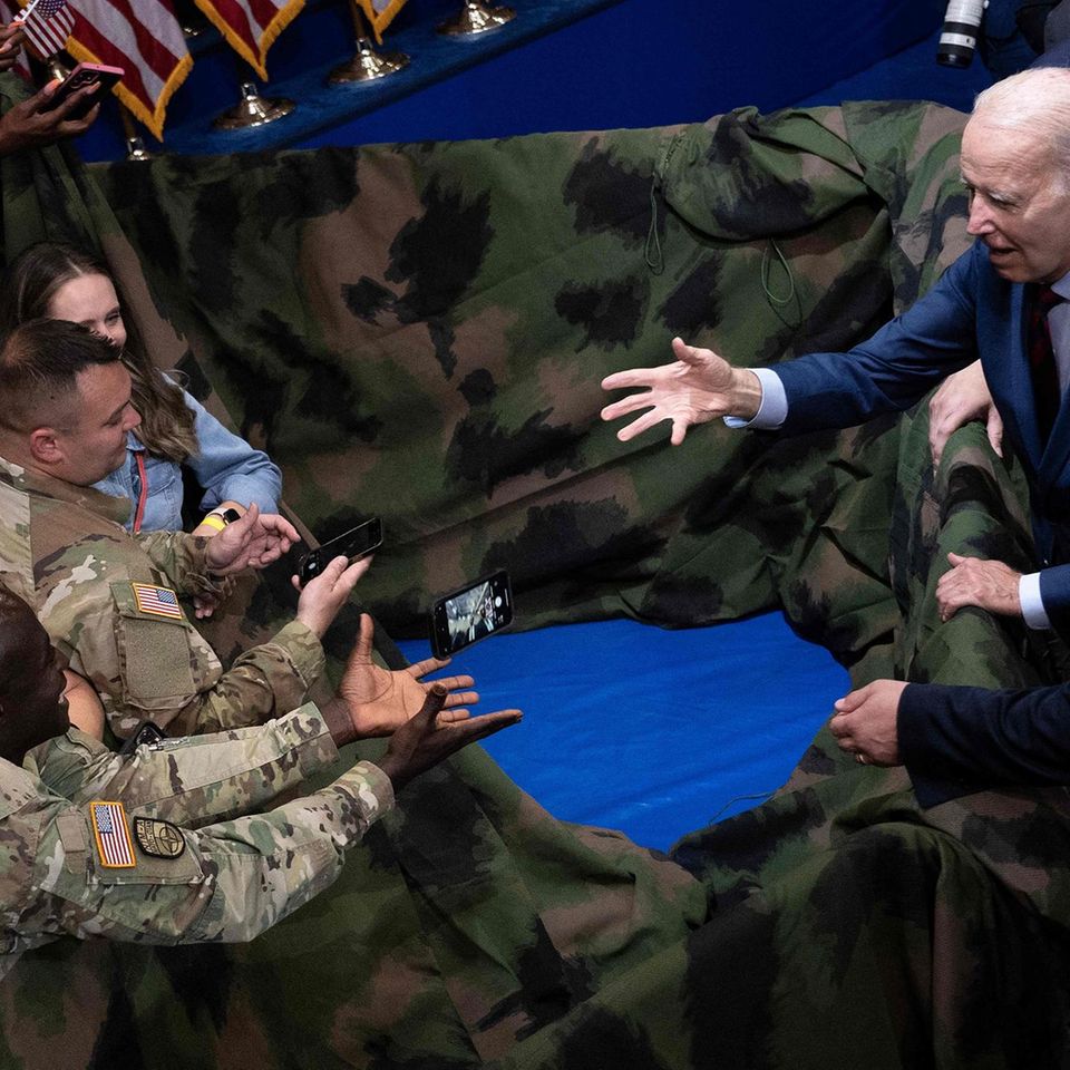 Fort Liberty, USA. US-Präsident Joe Biden wirft ein Mobiltelefon zurück, nachdem er ein Selfie mit Mitgliedern des US-Militärs und ihren Familien gemacht hat. Biden hatte an dem Armee-Stützpunkt im Bundesstaat North Carolina zuvor eine Rede gehalten. Sein Besuch gilt als Signal der Unterstützung von Militär- und Veteranenfamilien, Betreuern und Hinterbliebenen.