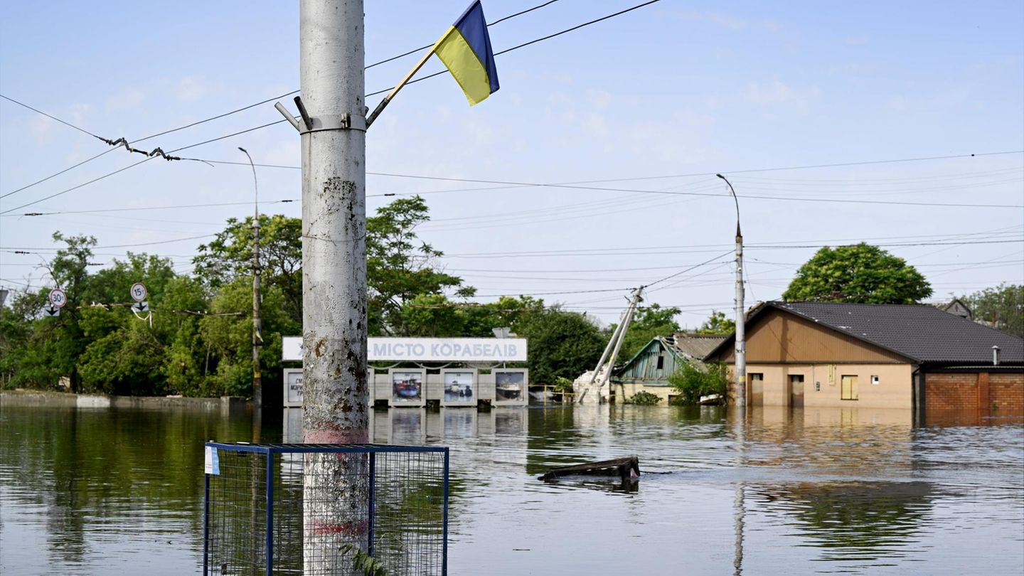 Fast trotzig weht eine ukrainische Flagge über den Wassermassen in Cherson