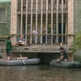 Freiwillige Helfer versorgen in ihren Wohnungen eingeschlossene Menschen per Schlauchboot mit Lebensmitteln