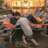 Helfer bringen einen alten Mann auf einer Trage in Sicherheit