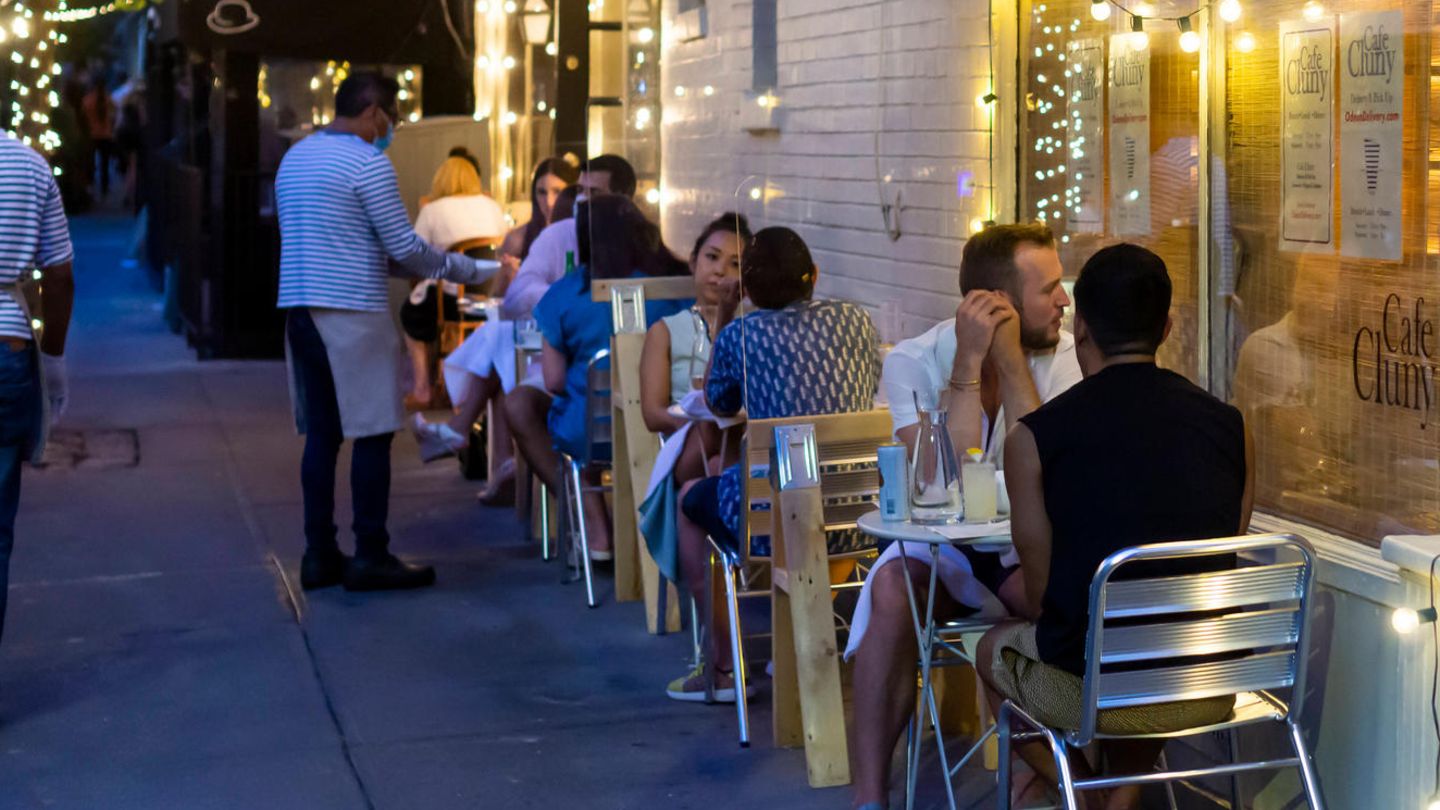 Menschen sitzen vor einem Restaurant in New York
