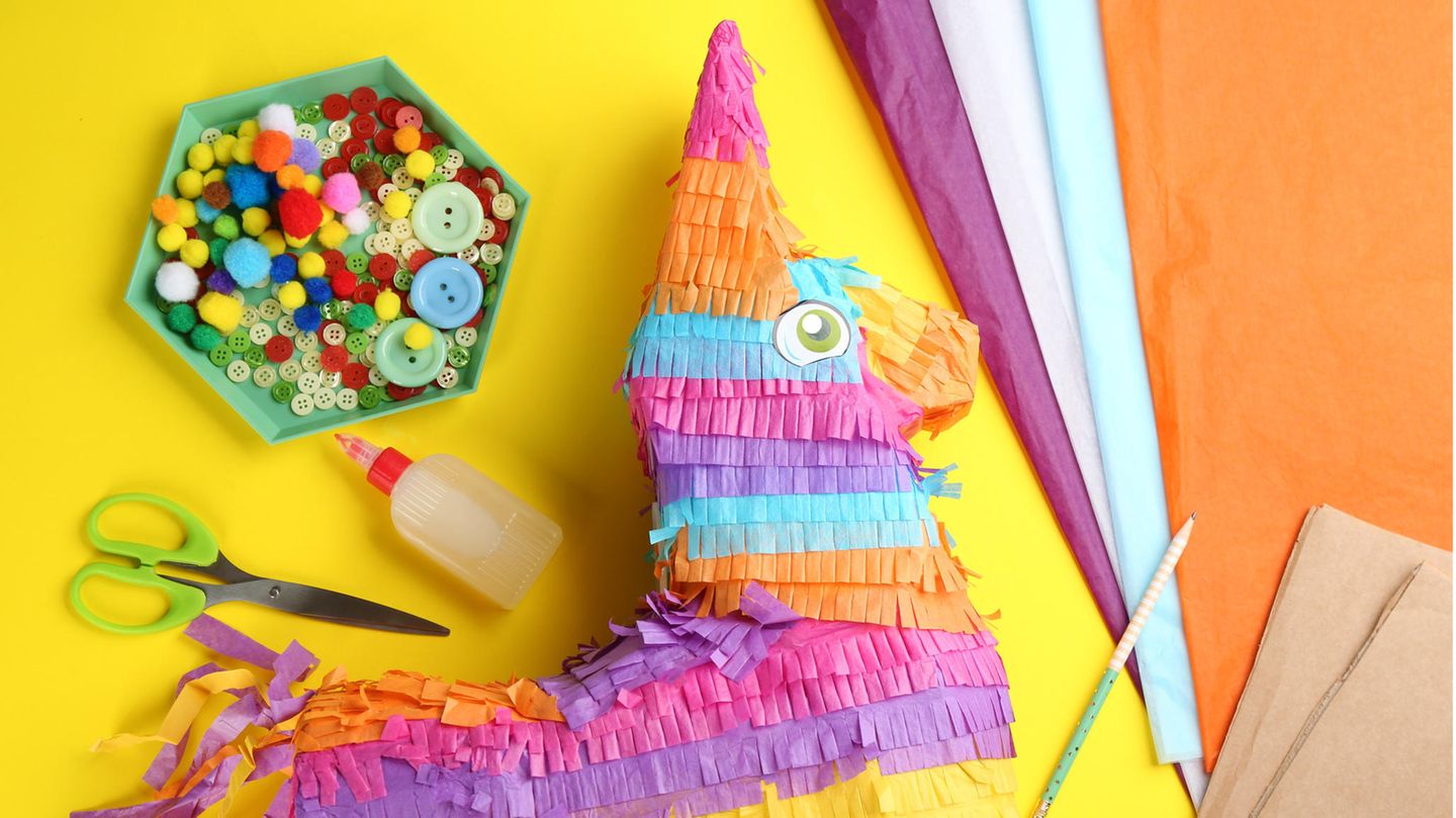 Flache Lay-Komposition mit Pappesel und Materialien auf gelbem Grund