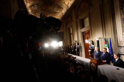 Silvio Berlusconi steht an einem Rednerpult