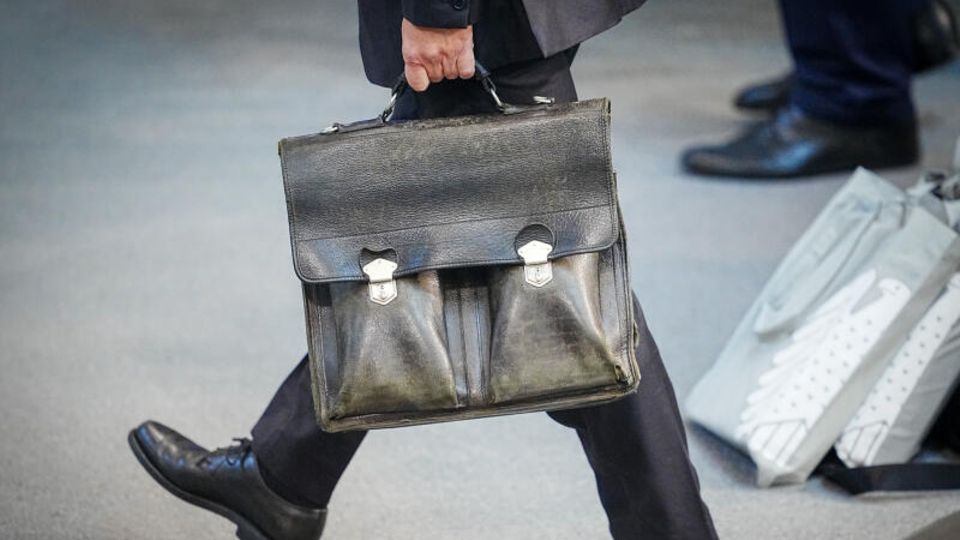 Bundeskanzler Olaf Scholz (SPD) trägt seine Aktentasche nach der Generaldebatte beim Verlassen des Plenarsaals im Bundestag