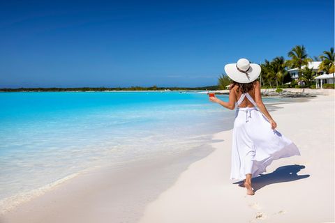 Frau am Strand in einem Kleid in der Nähe des Meeres