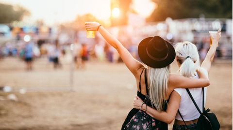 Zwei Frauen feiern bei einem Open Air Konzert.