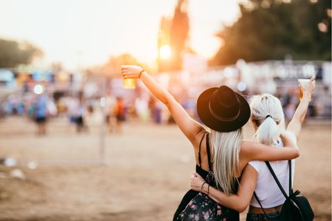 Zwei Frauen feiern bei einem Open Air Konzert.