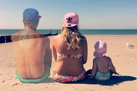 Die Familie sitzt am Strand. Der Mann verpasst langsam.