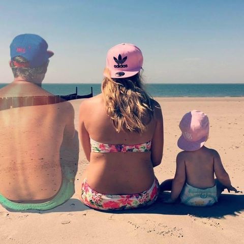 Die Familie sitzt am Strand. Der Mann verpasst langsam.