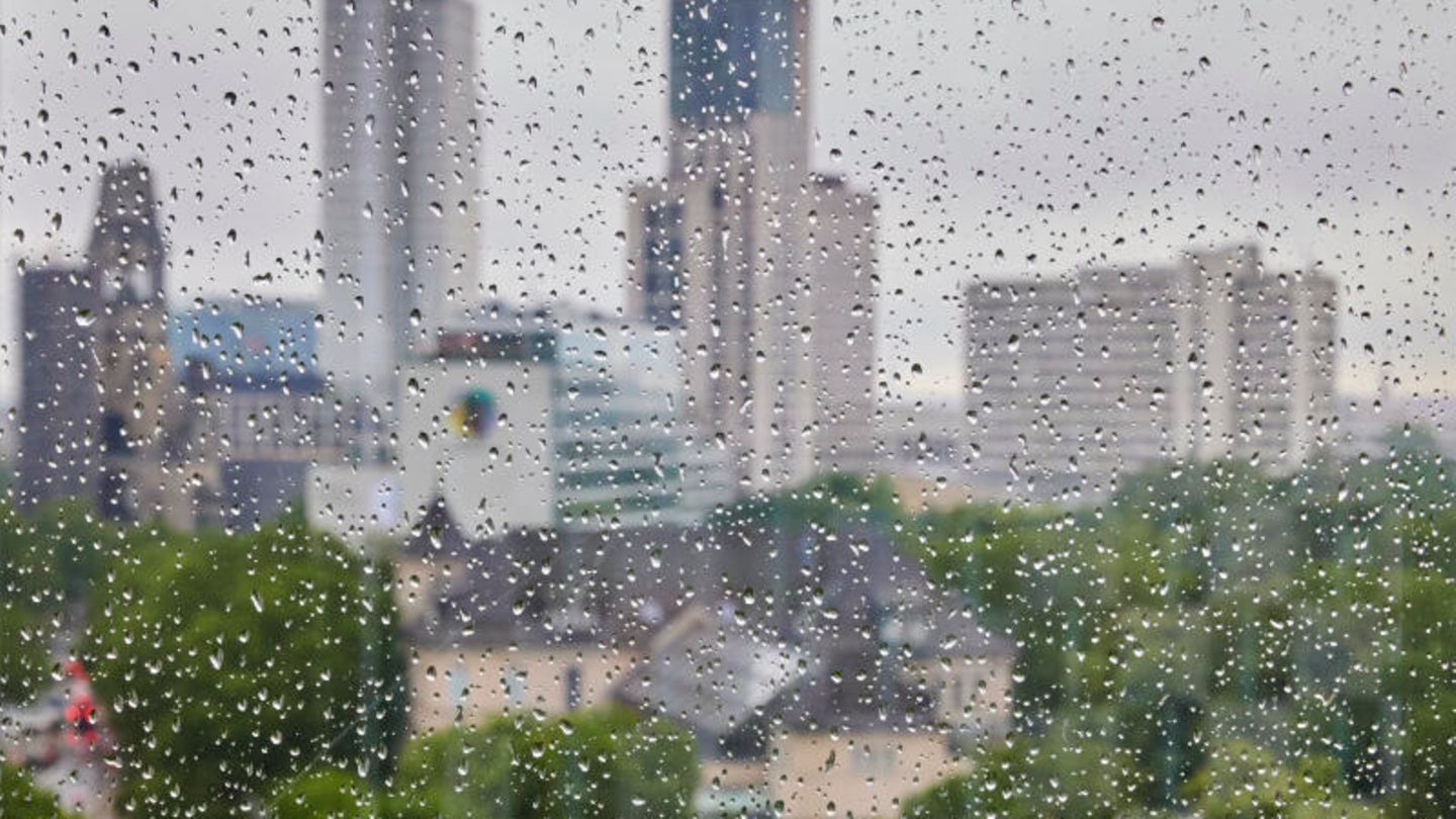 Berlin: Regentropfen sind an einer Fensterscheibe vor der Skyline der City West zu sehen