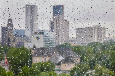 Berlin: Regentropfen sind an einer Fensterscheibe vor der Skyline der City West zu sehen
